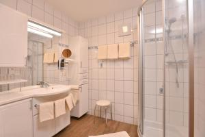 茵特斯托德Landhotel Gressenbauer的带淋浴和盥洗盆的白色浴室