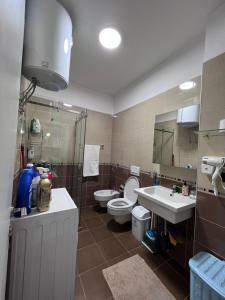 地拉那Downtown Grand Comfort的一间带卫生间、水槽和镜子的浴室