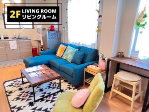 大阪Jen's House Osaka的客厅配有蓝色的沙发和桌子