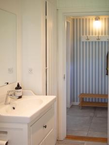 斯泰厄Kamilla's cottage, 1 km. from the beach的白色的浴室设有水槽和镜子
