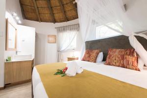 帕拉博鲁瓦赛非派旅行旅舍的一间卧室配有一张白色大床,床上有鲜花