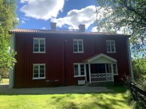 BrunskogBrunsbergs Herrgård appartement的一间红色的房子,有白色的窗户和院子