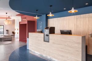 马托西纽什B&B HOTEL Porto Expo Aeroporto的一个带前台柜台和蓝色墙壁的办公大堂