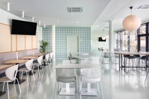 马托西纽什B&B HOTEL Porto Expo Aeroporto的餐厅设有桌椅和平面电视。