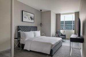 多哈Steigenberger Residence Doha的酒店客房,配有白色的床和椅子