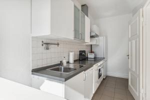 柏林Bright 3-room apartment near Prenzlauer Berg的厨房配有水槽和白色橱柜