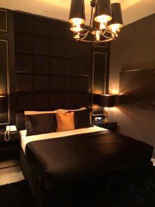 利雅德Dana Hotel & Residences 2的一间卧室配有一张大床和黑色床头板