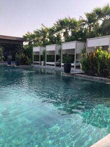 利雅德Dana Hotel & Residences 2的一座拥有绿松石水和棕榈树的游泳池