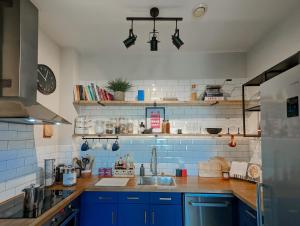 QuedgeleySpacious, Mid-Century 1 bedroom Apartment的厨房配有蓝色橱柜和水槽