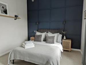 QuedgeleySpacious, Mid-Century 1 bedroom Apartment的一间卧室配有一张带蓝色墙壁的大床