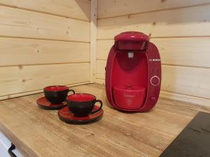斯托尼拉斯奇Chata Rafusa pod Śnieżnikiem的红色咖啡壶,桌子上放两个杯子