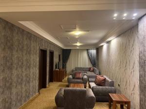 埃尔比勒Jouhayna Hotel&Suite的一间设有三张沙发、一张沙发和一张桌子的房间
