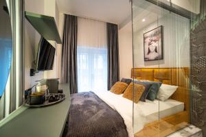 贝尔格莱德Natali luxury suites- mini rooms的一间卧室设有一张床和玻璃墙