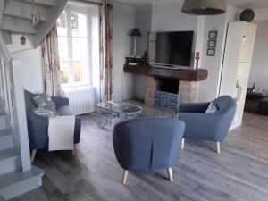 朗西厄Maison vue exeptionnelle sur la mer的客厅配有蓝色椅子和壁炉