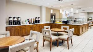 奥兰多Staybridge Suites Orlando Royale Parc Suites, an IHG Hotel的一间带桌椅和柜台的餐厅