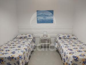 托雷拉皮罗Villa Mariposa n°3的一间卧室配有两张床和一张小桌子