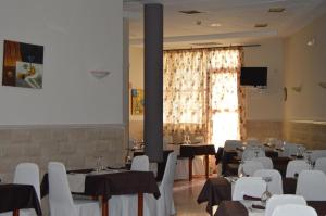 马尔帕尔蒂达德卡塞雷斯Hotel Peña Cruz的客房设有桌椅和大窗户。
