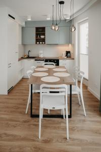 米兹多洛杰Norwida 17的厨房配有桌子和白色椅子