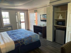 孟菲斯KINGS INN- Medical Downtown Midtown Memphis的一间卧室配有一张床、一张书桌和一台电视