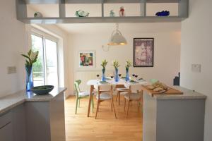 奥尔德堡Aldeburgh Lodge Gardens的厨房以及带桌椅的用餐室。