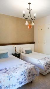 卡法亚特Casa del Sol Cafayate的一间卧室配有两张床和吊灯。