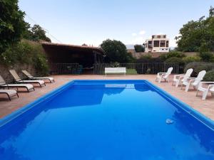 卡法亚特Casa del Sol Cafayate的蓝色游泳池,带椅子