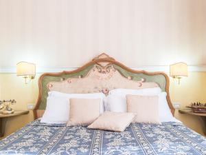 罗马Il乔托帕多瑞莱斯酒店的一间卧室配有带白色枕头的床