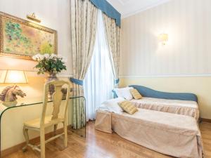 罗马Il乔托帕多瑞莱斯酒店的卧室配有床、椅子和窗户。
