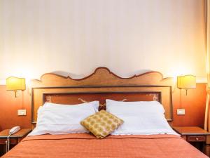 罗马Il乔托帕多瑞莱斯酒店的一间卧室配有带白色枕头的床