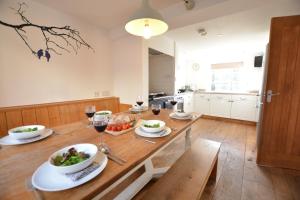 绍斯沃尔德Ferry Cottage, Southwold的厨房配有带食品和酒杯的木桌