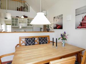 布拉万德4 person holiday home in Bl vand的一间带木桌和椅子的用餐室