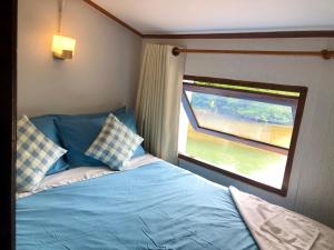 象岛阁昌岛班查蕾度假村的一间卧室设有蓝色的床和窗户。