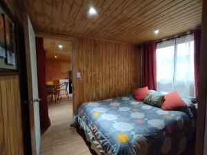 Rio ClaroEl Fogon de Rio Claro的木制客房内的一间卧室,配有一张床
