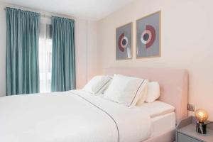大加那利岛拉斯帕尔马斯Moderno piso en Las Palmas de Gran Canaria的卧室配有白色的床和绿色窗帘