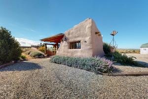 Arroyo HondoCasa de Taos的沙砾车道中间的小房子