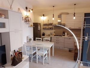 罗马Tiny Green apartament in Rome - Magliana的厨房配有白色的桌椅