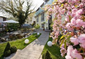 萨尔茨堡罗森维拉酒店的一座种有粉红色花卉的花园及一座建筑