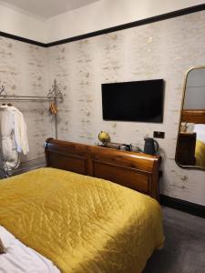 布莱克本The Ribchester Arms的卧室配有一张床,墙上配有电视