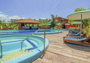 卡庞达卡诺阿Hotel Acqua Lokos的度假村的游泳池,配有椅子和遮阳伞