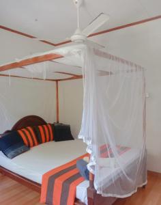 米迪加马东Romaclan Villa的一间卧室配有一张带吊扇的床