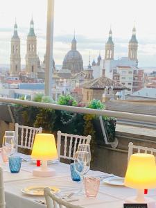 萨拉戈萨罗斯杰拉索勒斯公寓的一张带酒杯的桌子,享有城市美景