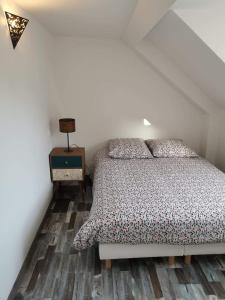 埃塔普勒La Belle Etaploise的一间卧室配有一张床,铺有木地板