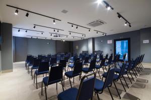 克里西玛Hotel Darolt Criciúma的一间会议室,配有蓝色椅子和讲台