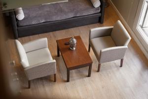 罗萨里奥Carat Apart Boutique的客厅配有两把椅子、一张桌子和一张沙发