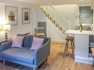 达特茅斯Silver Cottage的客厅设有蓝色的沙发和楼梯。