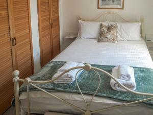 达特茅斯Silver Cottage的一间卧室配有带毛巾的床