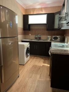 安曼Ronza Elegant Apartment的厨房配有冰箱、洗衣机和烘干机