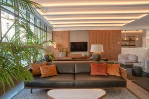 波尔图NH Porto Jardim的客厅配有真皮沙发和电视