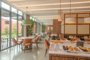 波尔图NH Porto Jardim的用餐室设有桌椅和窗户。
