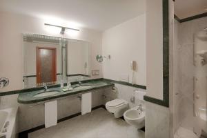 莱科莱科彭特维奇欧NH酒店的浴室设有2个水槽、卫生间和镜子。